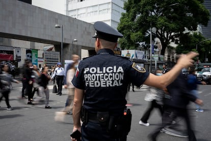 Un policía evacúa a las personas del edificio de Cancillería mexicana.