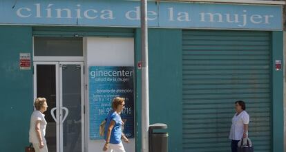 Vecinas de M&aacute;laga pasan frente a la cl&iacute;nica donde se han registrado los supuestos acosos.