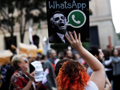 Uma mulher segura um cartaz, durante um protesto em São Paulo, contra suposto disparo em massa de notícias falsas em favor de Jair Bolsonaro.