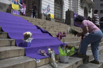 Mulher deposita flores em escadaria em homenagem a Marielle e Anderson.