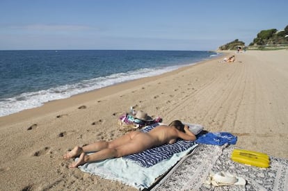 Una dona pren el sol a la platja de la Murtra a Sant Pol de Mar (Maresme).