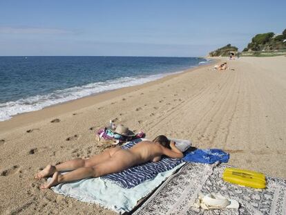 Una dona pren el sol a la platja de la Murtra a Sant Pol de Mar (Maresme).