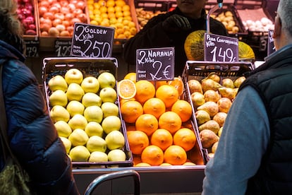 Clientes en un puesto de frutas y verduras en el Mercado Central de Zaragoza, el pasado jueves.