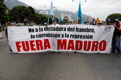 Manifestantes portan una pancarta que dice "No a la dictadura del hambre, la corrupción y la represión. Fuera Maduro.", en Caracas (Venezuela).