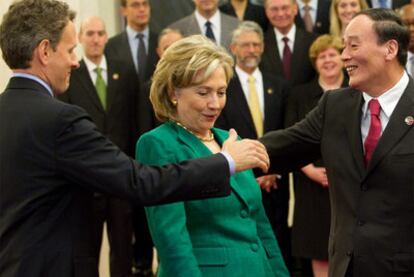 El viceprimer ministro chino Wang Qishan saluda al secretario del Tesoro estadounidense, Timothy Geithner, en presencia de Hillary Clinton.
