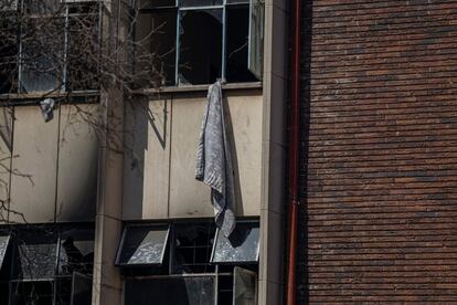 Una manta cuelga de una de las ventanas que los residentes del inmueble siniestrado usaron para escapar de las llamas. 