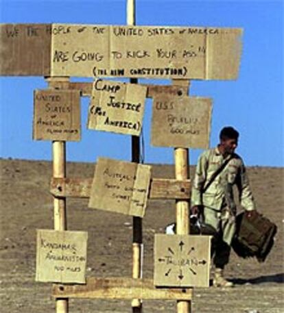 Un <i>marine</i> de la base levantada al sureste de Afganistán transporta bolsas de arena.