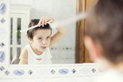 Un ni&ntilde;o se repeina frente al espejo. 