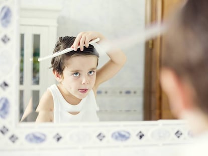 Un ni&ntilde;o se repeina frente al espejo. 