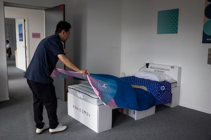 Un empleado de la Villa Olímpica muestra las camas fabricadas de cartón y los colchones de diferentes densidades. 