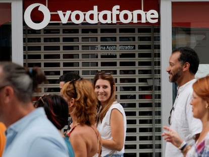 Ciudadanos delante de un establecimiento de Vodafone, en Ronda, Málaga.