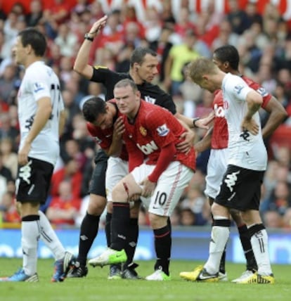 Van Persie ayuda a Rooney, con un profundo corte en la pierna tras chocar con Rodallega.
