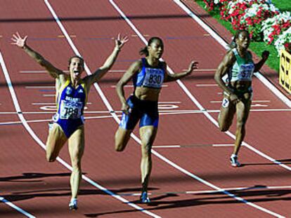 Zhanna Pintusevich levanta los brazos al cruzar la línea de meta por delante de Marion Jones.