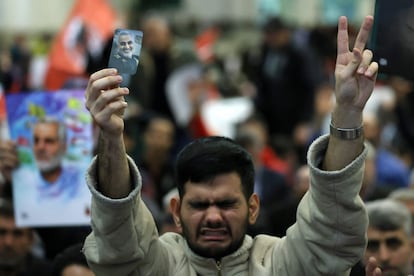 Un iraní muestra el signo de la victoria y sostiene un retrato del asesinado comandante iraní Qasem Soleimani, durante la ceremonia de conmemoración del aniversario de su muerte en la capital iraní, Teherán, el miércoles 3 de enero.
