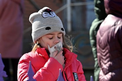 Una niña besa a su ratón cerca de un edificio residencial que se derrumbó parcialmente tras un bombardeo en Kiev, el 18 de marzo.