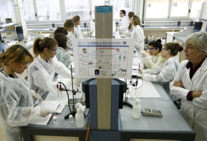 A la derecha, Nuria Sotomayor, profesora de Química Orgánica de la UPV, explica a alumnas de bachillerato un experimento.