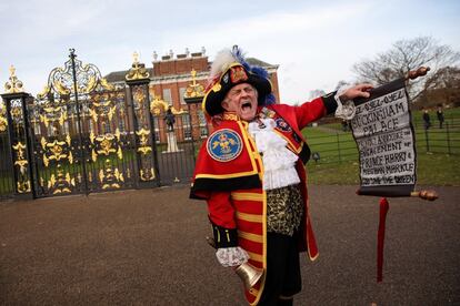 Tony Appleton vestido de pregonero toca una camapana mientras anuncia el compromiso entre el príncipe Harry y Meghan Markle, en las afueras del palacio de Kensington en Londres (Reino Unido).