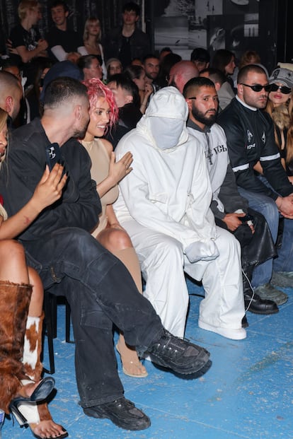 Bianca Censori y Kanye West sentado en el front row.