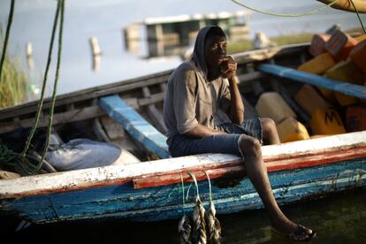 Un pescador se sienta en su barco en el lago Azuei (Haití).
