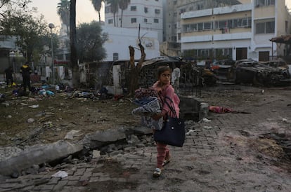 Una niña palestina recoge objetos tras el ataque en el hospital de Al Ahli en Gaza, este miércoles.