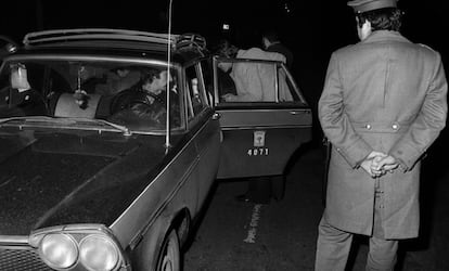 Unos clientes suben a un taxi ante la mirada de un agente de la Policía Armada en 1978 en Madrid. Por entonces los taxis eran negros con una franja roja (que en verano de 1980 pasaron a ser blancos). A finales de año, la bajada de bandera costaba 25 pesetas y el kilómetro recorrido, 15; la hora parada 375, y la nocturnidad, 25.