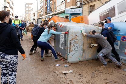 Voluntarios ayudan en las labores de limpieza de las calles de Alfafar, Valencia, este domingo.