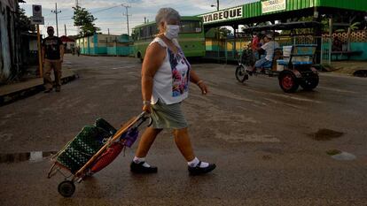 Una mujer con mascarilla camina por una calle de San José de las Lajas (Cuba) con un carrito de la compra el pasado 18 de junio de 2020.