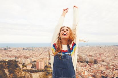 Una mujer alza los brazos pletórica con Barcelona de fondo.