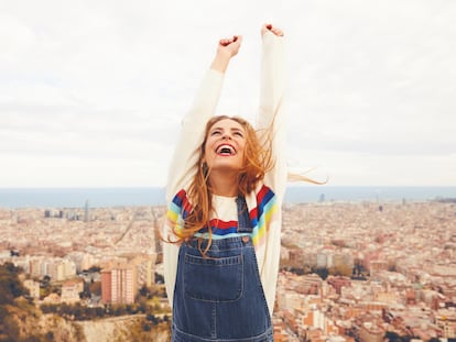 Una mujer alza los brazos pletórica con Barcelona de fondo.