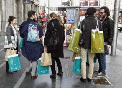 Un grupo de consumidores a la salida de una tienda  en la Gran Vía de Madrid. EFE/Archivo