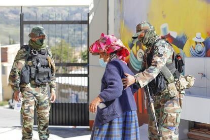 Soldados ayudan a una mujer mayor en el colegio electoral de Huaraz, Perú. 