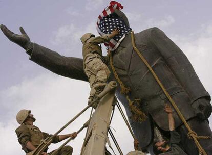 Soldados de EE UU cubren con la bandera de su país la cara de la estatua de Sadam Husein.
