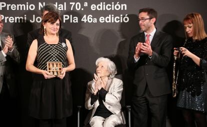 Carmen Amoraga con el premio en las manos recibe el aplauso de Ana María Matute, sentada.