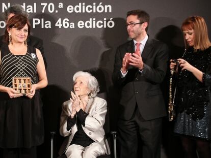 Carmen Amoraga con el premio en las manos recibe el aplauso de Ana María Matute, sentada.
