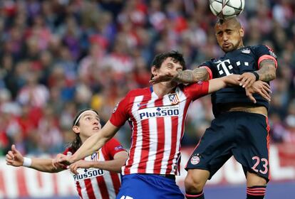 El defensa montenegrino del Atlético de Madrid Stefan Savic (c) salta por el balón con el chileno Arturo Vidal (d), del Bayern de Múnich.