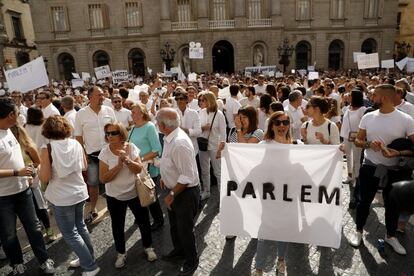 Una mujer porta una sabana con la palaba "Parlem" a favor de un diálogo en Barcelona.