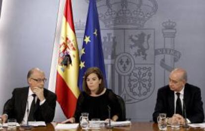 La vicepresidenta del Gobierno, Soraya Sáenz de Santamaría y los ministros de Hacienda, Cristóbal Montoro (i) e Interior, Jorge Fernández Díaz, durante la rueda de prensa posterior a la reunión del Consejo de Ministros que ha tenido lugar en La Moncloa.