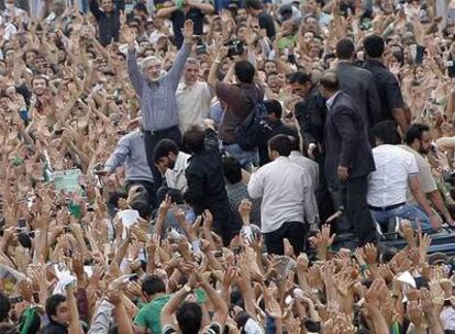 El líder reformista Mir Hosein Musaví saluda brazos en alto a sus seguidores en la gran manifestación de ayer en Teherán.