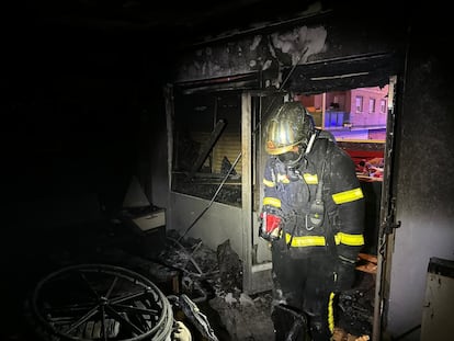 Un bombero, en el salón de la vivienda de Alcalá de Henares en la que se ha desatado el incendio.