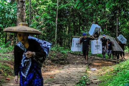 Baduy men carry ballot boxes for distribution to polling stations centre ahead of the presidential election at Kanekes village in Lebak, Banten province, Indonesia, February 13, 2024