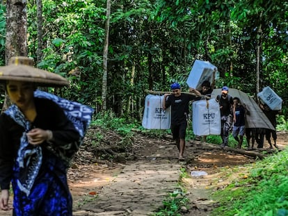 Baduy men carry ballot boxes for distribution to polling stations center ahead of the presidential election at Kanekes village in Lebak, Indonesia, February 13, 2024.