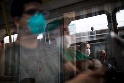 Viajeros que llevan máscaras protectoras como precaución contra la propagación del nuevo virus corona, viajan en un autobús público en Lima, Perú.