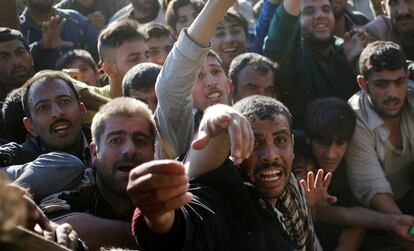 Un grupo de hombres esperan recibir alimentos de una organización gubernamental iraquí, a las afueras de Mosul el 20 de noviembre.