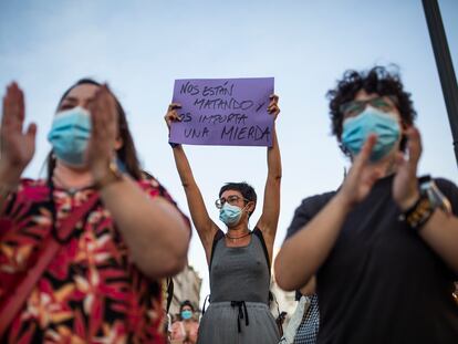 Una mujer sostiene un cartel junto a otros asistentes a una concentración contra la violencia de género, el 6 de agosto en Madrid.