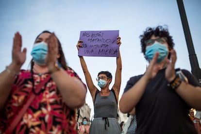 Una mujer sostiene un cartel junto a otros asistentes a una concentración contra la violencia de género, el 6 de agosto en Madrid.