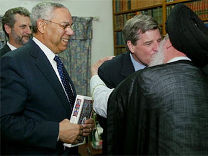 El administrador de EE UU en Irak, Paul Bremer, besa al ayatolá Al Sader en presencia de Colin Powell, ayer en Bagdad.