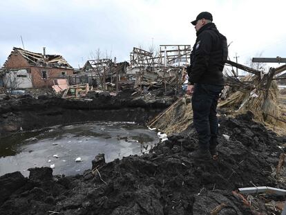 Un policía examina un cráter después del bombardeo ruso en Vovchans'k, este jueves.