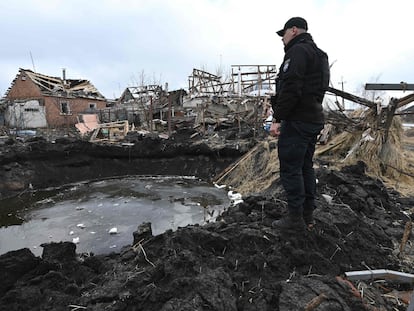 Un policía examina un cráter después del bombardeo ruso en Vovchans'k, este jueves.