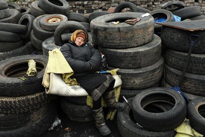 Una mujer ucrania duerme en los neumáticos de una barricada levantada en el centro de Kiev. 23 de febrero de 2014.