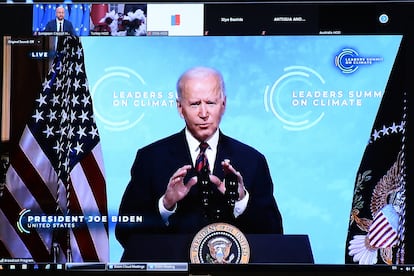 US President Joe Biden is seen on the screen as he attends the leaders summit on climate via video conference, in Brussels on April 22, 2021. (Photo by JOHANNA GERON / POOL / AFP)